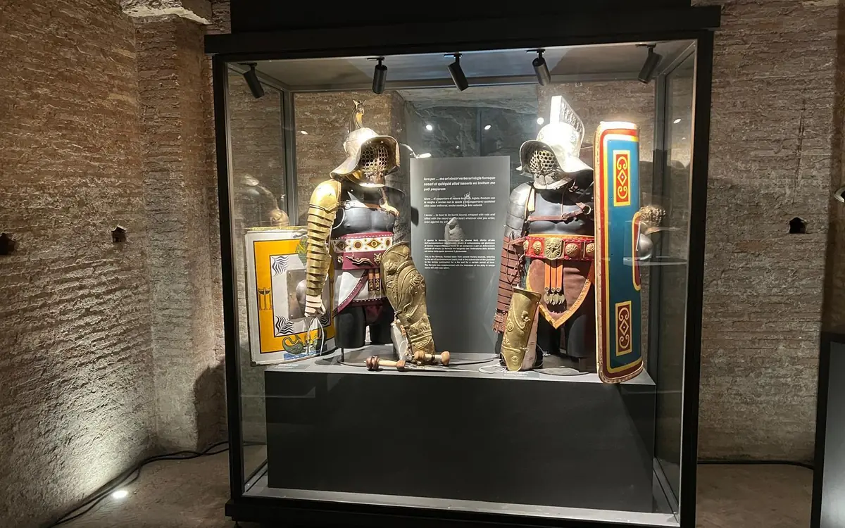 A display of Roman gladiatorial armour and helmets in a museum case
