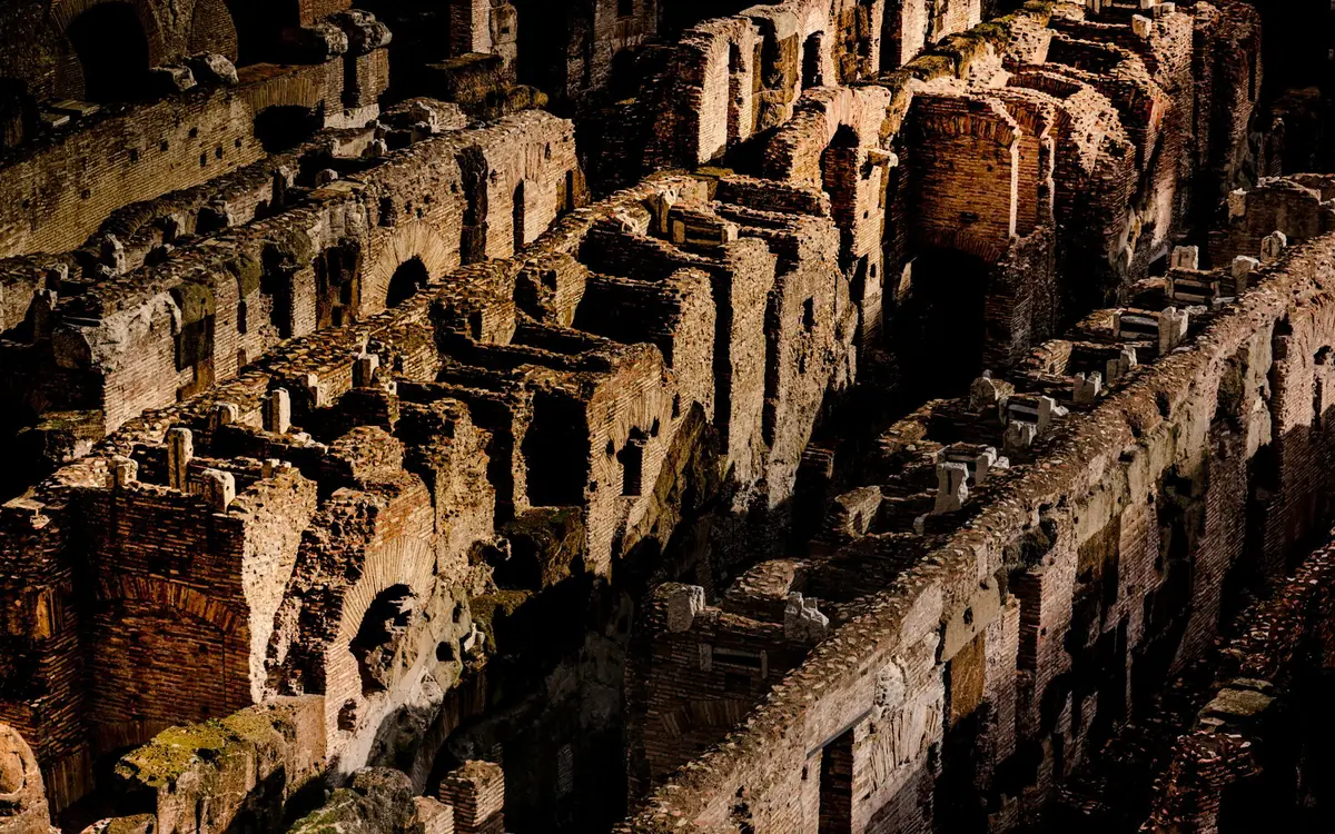 The arches of the Colosseum lit from within after dark