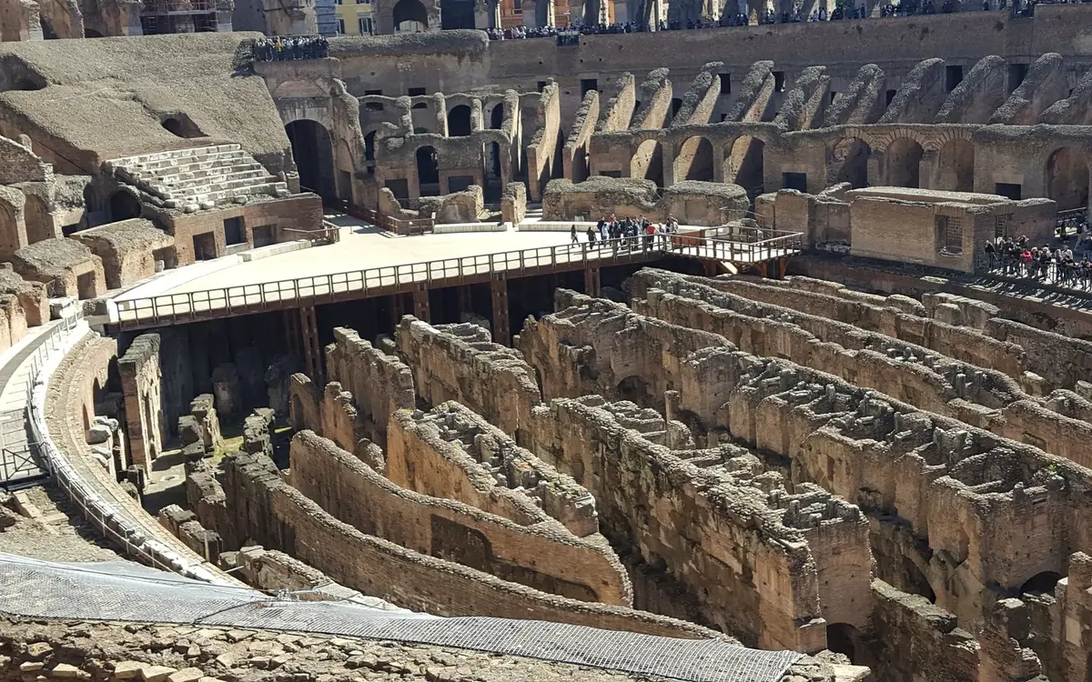 A walkway through the upper level of the Colosseum with visitors along it
